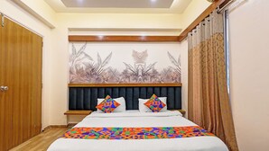 Un dormitorio con cama, cabecera, un mural en la pared y una ventana con cortinas.