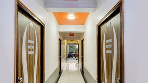 Corredor de hotel com portas de madeira, com os números 304 e 306, que dá para uma varanda com vista.