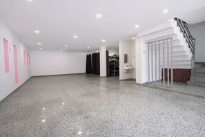 Ein geräumiger, moderner Innenraum mit einem glänzenden Boden, einer Treppe und einem sichtbaren Badezimmer mit Waschbecken.