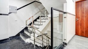 Eine moderne Treppe mit Glastrennwand und einer Holztür.