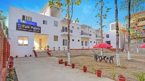 Un hôtel appelé « Fab Hotels Park Palace » qui possède une cour intérieure agrémentée de plantes en pot et d’un espace de détente extérieur.