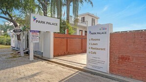 Une enseigne pour le Park Palace, indiquant la présence d’installations telles que des chambres, une pelouse, un restaurant et un café.