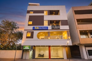 A multi-story hotel with 'fabHOTELS' and 'THE PVS GRAND HOTEL' signage, a glass entrance, and a visible balcony. - Fabhotel Pvs Grand (New Delhi)