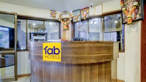 Uma receção com acabamento em madeira e um letreiro amarelo com a inscrição "fab HOTELS".