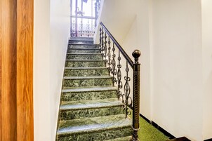 A staircase with marble steps and ornate metal railings.
