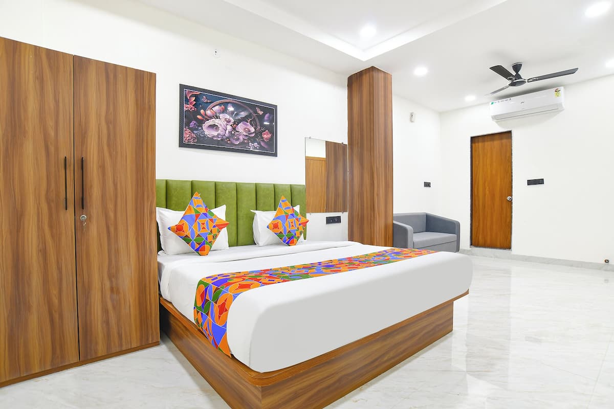 Un dormitorio moderno con cama, armario y zona de estar.