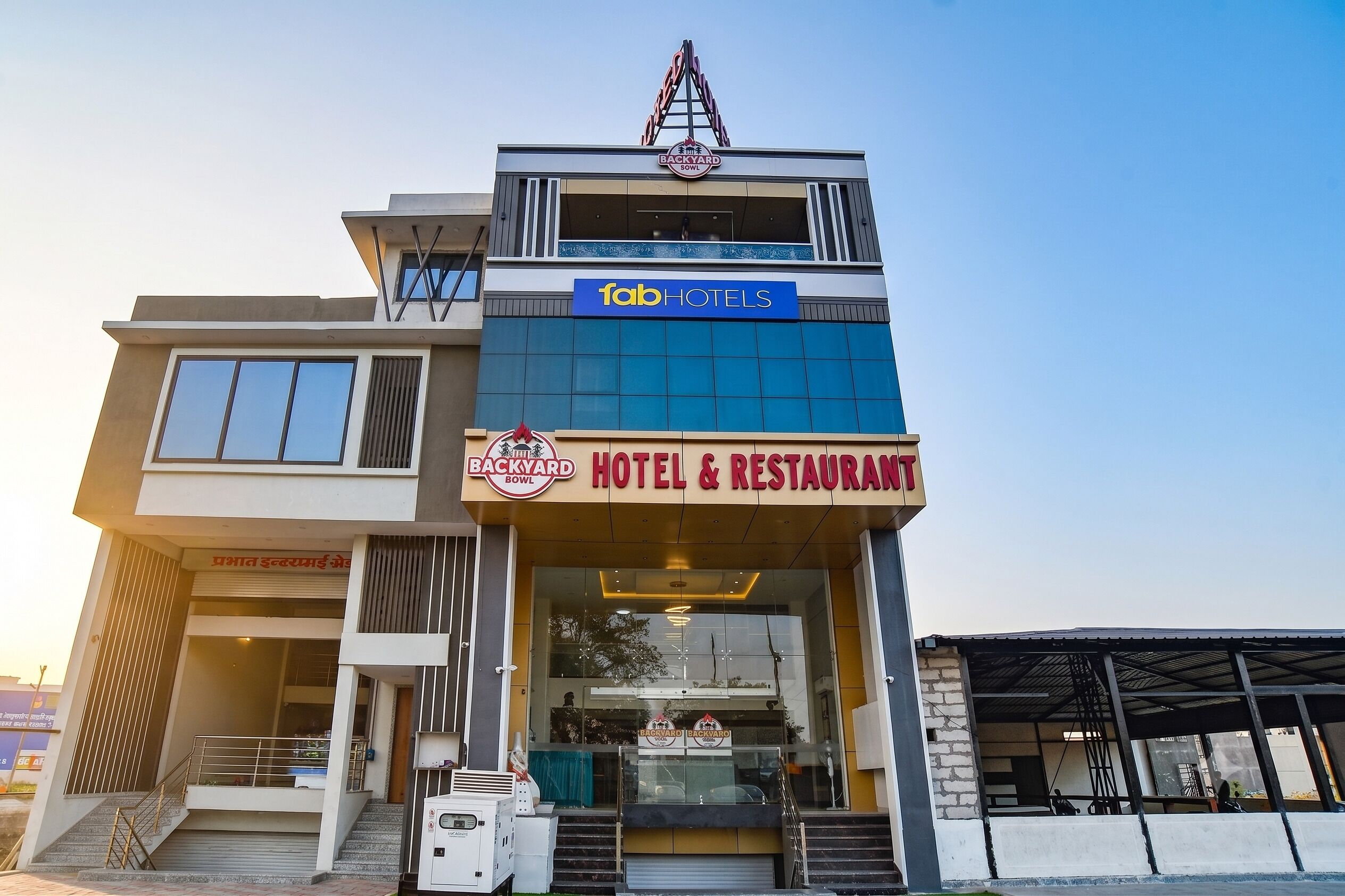 En bygning med flere etager, hvor der er et skilt med hotel og restaurant i stueetagen.