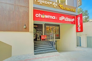 Un edificio con un letrero rojo que dice 'chowman' y un letrero encima que dice 'Global Stay'.