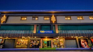 Un hôtel reconnaissable à son enseigne bien visible, à ses nombreuses fenêtres et à sa devanture où sont exposés les produits en vente.