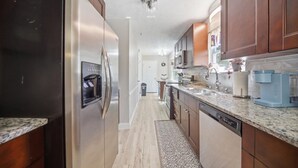 A kitchen with stainless steel appliances, wooden cabinets, a granite countertop, and a dishwasher. - 6 mi to Stone Mountain Park – Cozy Family Retreat (Snellville)