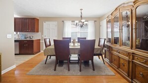A dining area with a table, chairs, a chandelier, and a wooden cabinet. - 6 mi to Stone Mountain Park – Cozy Family Retreat (Snellville)