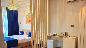 A hotel room with a bed, desk, wardrobe, and an air conditioning unit. - Gold Perla De Mar Hotel (Baku)