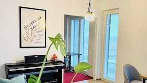A modern living room with a piano, a large plant, and a framed artwork on the wall. - Nordic home bliss with music moments (Helsinki)