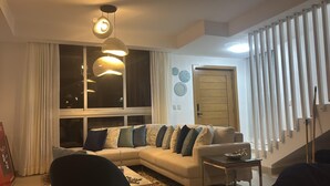 Una sala de estar con un sofá, una mesa de centro y una lámpara colgante.
