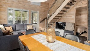 Un intérieur en bois comprenant un canapé, une table à manger et un escalier.