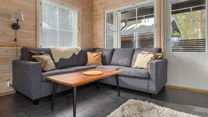 Un salon moderne avec un canapé gris, une table basse en bois et un tapis moelleux.