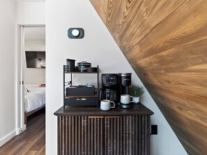 A kitchenette with a coffee maker, mugs, and a shelf with kitchenware. - A-Frame Cabin • Hot Tub + Sauna • Near Pigeon Forge | Fireside on Mortar (Sevierville)