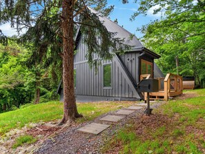 A cabin with a sloped roof, a wooden deck, and a large tree in front. - A-Frame Cabin • Hot Tub + Sauna • Near Pigeon Forge | Fireside on Mortar (Sevierville)