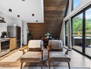 A modern kitchen with a dining area, wooden ceiling, and large windows. - A-Frame Cabin • Hot Tub + Sauna • Near Pigeon Forge | Fireside on Mortar (Sevierville)