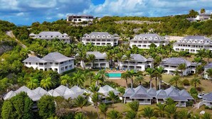Un complexe hôtelier comprenant plusieurs bâtiments, une plage avec des transats et une piscine.