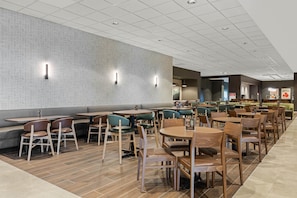 A modern restaurant with a variety of seating options including booths, tables, and chairs. - Drury Plaza Hotel Nashville Southeast Century Farms (Antioch)