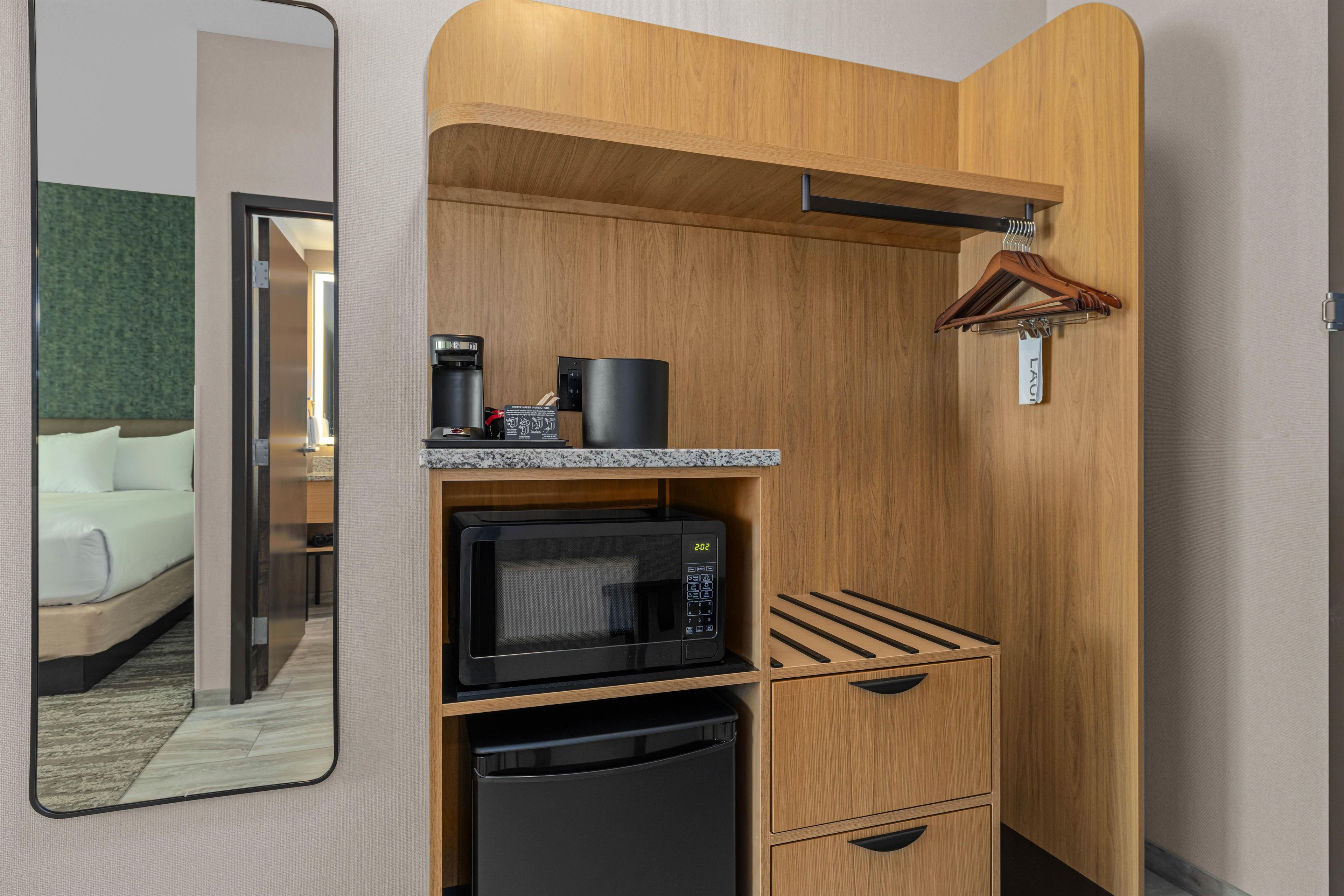 A compact kitchenette with a microwave, coffee maker, and a small refrigerator.