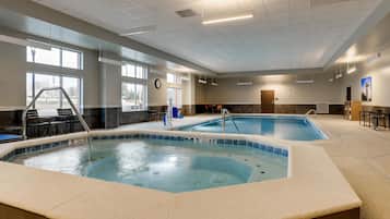 Una piscina techada, sillones reclinables de piscina