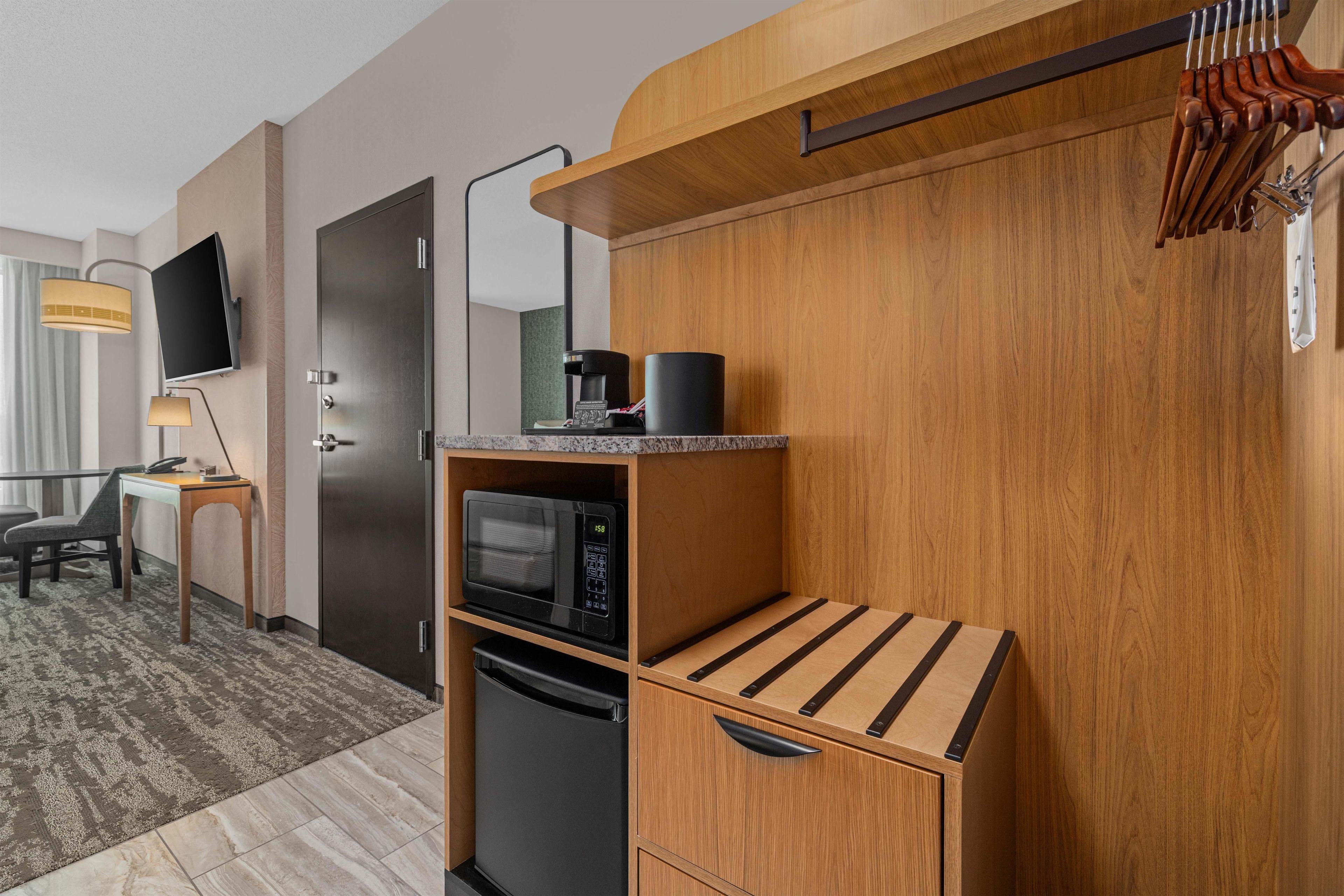 A compact kitchenette with a microwave, coffee maker, and a small refrigerator.