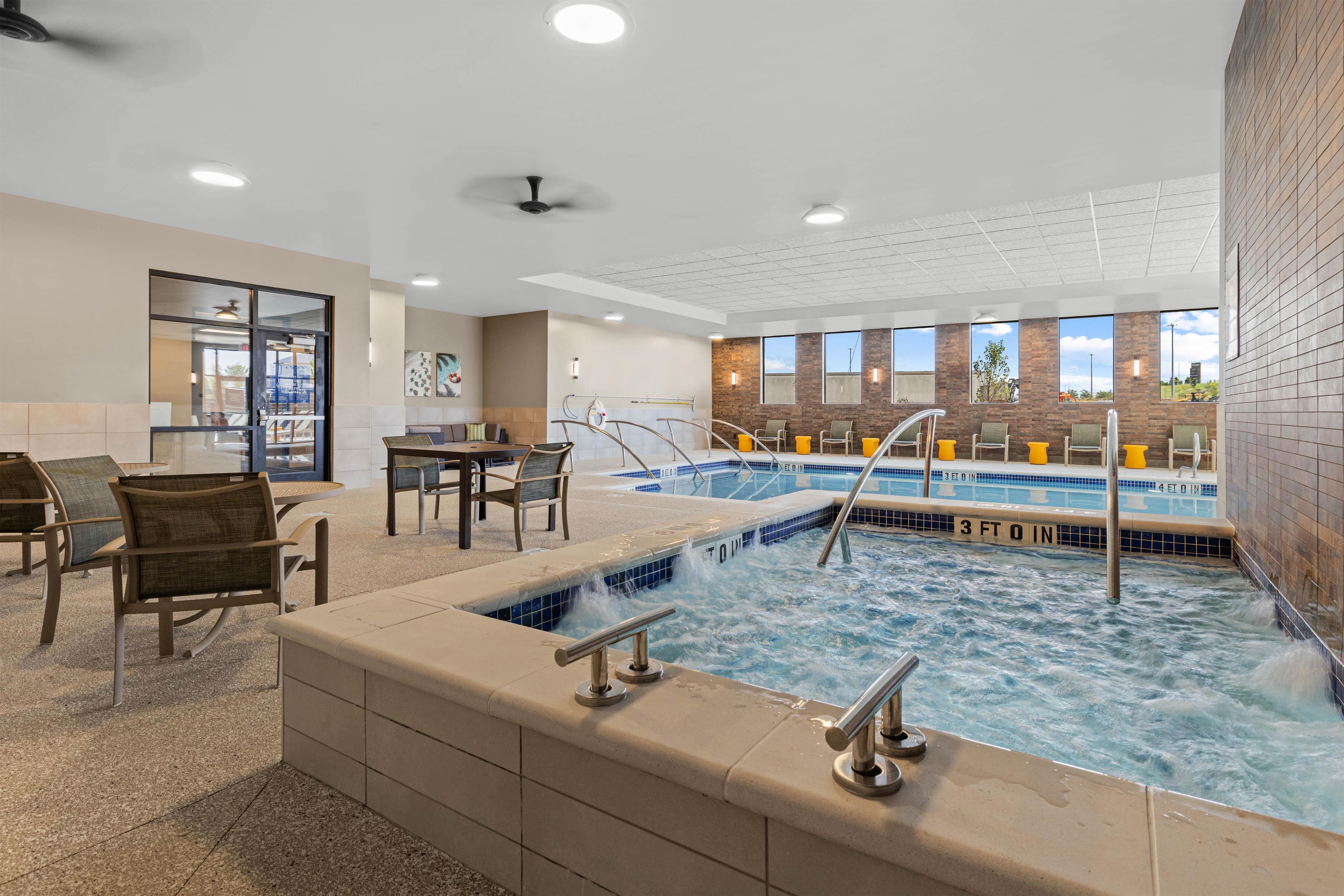 A hotel lobby with a pool area, seating, and a reception desk.
