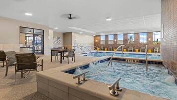 A hotel lobby with a pool area, seating, and a reception desk.