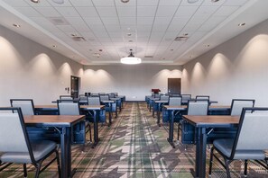 A conference room with rows of tables and chairs, a patterned carpet, and a ceiling with recessed lighting. - Drury Plaza Hotel Nashville Southeast Century Farms (Antioch)