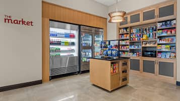 Um quiosque de autoatendimento com máquinas dispensadoras de bebidas geladas e diversos snacks e bebidas.
