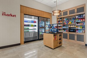 A self-service kiosk with refrigerated beverage dispensers and a variety of snacks and beverages. - Drury Plaza Hotel Nashville Southeast Century Farms (Antioch)