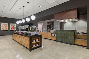 A modern kitchen with a central island, a stove, and a range hood. - Drury Plaza Hotel Nashville Southeast Century Farms (Antioch)