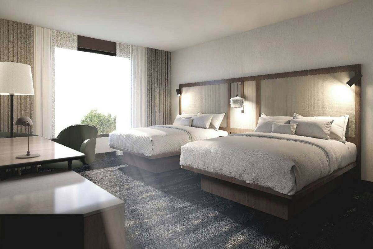 Una habitación de hotel con dos camas, un escritorio y una silla.