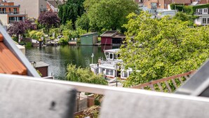 A canal with boats, a small dock, and buildings with red roofs. - Apartment "Seeterrasse" with Lake View, Shared Terrace and Wi-Fi (Malchow)