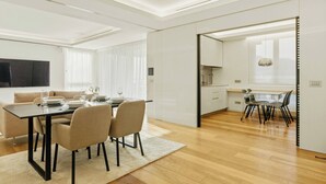 A modern living room with a dining area, a kitchen, and a TV. - Generoso Luxury Lake View Suite in Lugano (Lugano)
