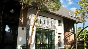 The exterior of Azz Hotel with a modern design, large windows, and a well-maintained garden area. - AZZ Hotel (Chiang Mai)