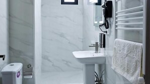 Ein modernes Badezimmer mit Toilette, Waschbecken und Dusche.