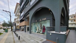 Ein Schaufenster mit einem Schild, auf dem "FIERA FUR" steht, und Kleiderträger, die Kleidung präsentieren.