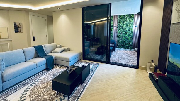 Un salon moderne avec un canapé, une table basse et un téléviseur.