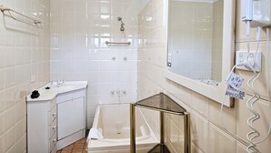 Ein Badezimmer mit Badewanne, Waschbecken und Spiegel.