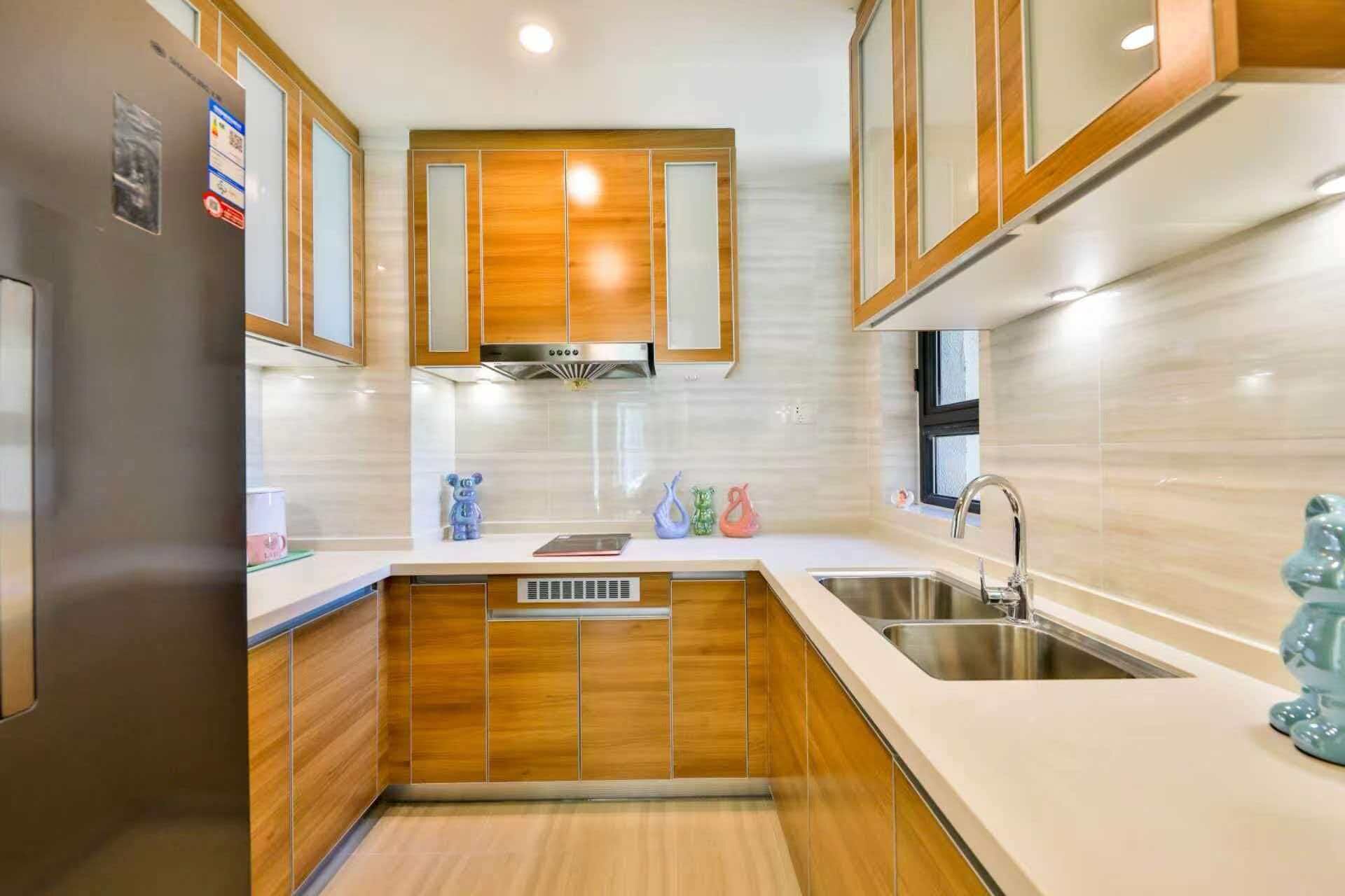 Una cocina moderna con armarios de madera, un lavamanos de acero inoxidable y un horno empotrado.