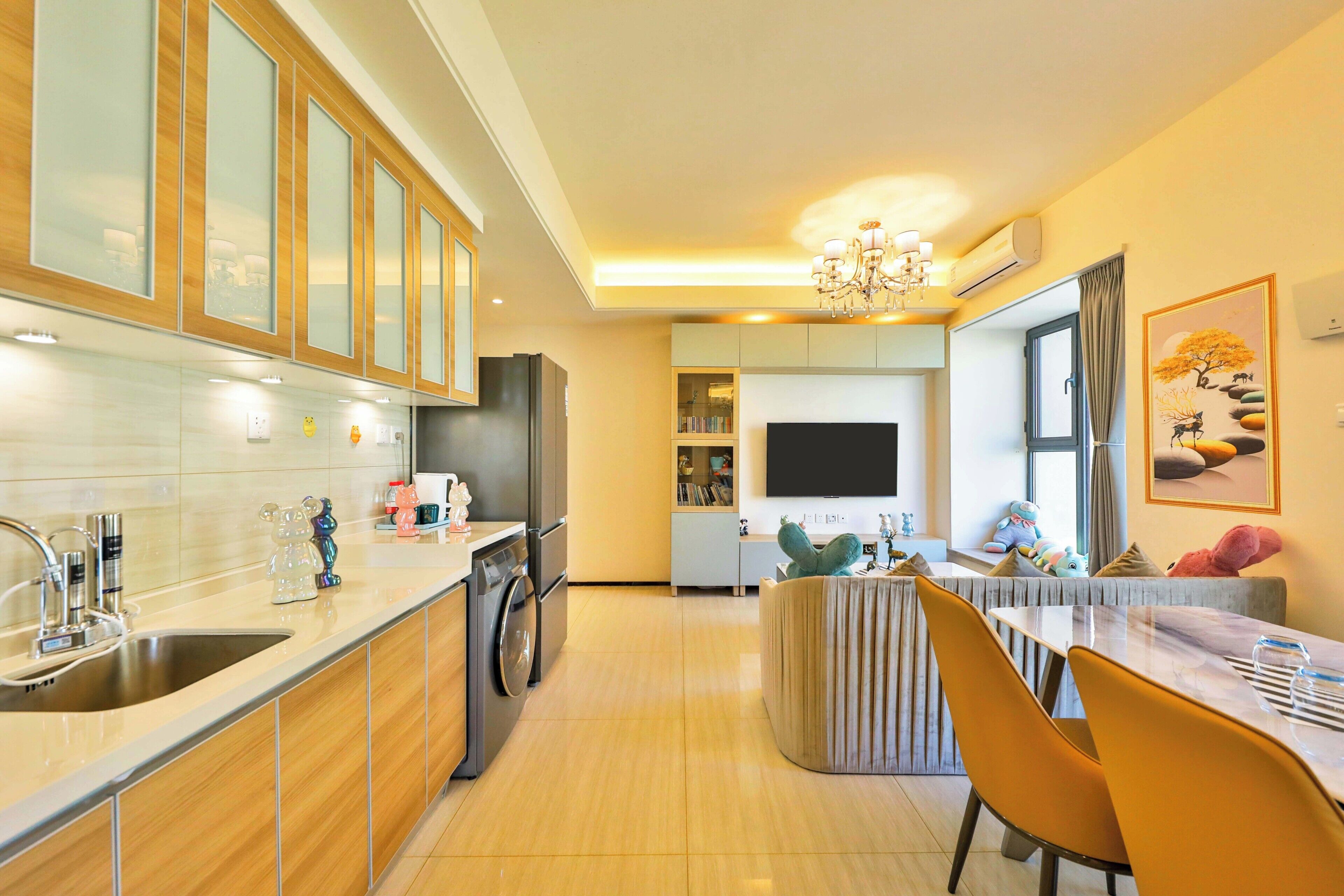 Een moderne keuken met een ingebouwde oven, een spoelbak en een eethoek met een tafel en stoelen.
