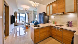 Una cocina moderna con armarios de madera, horno empotrado y pileta de acero inoxidable.