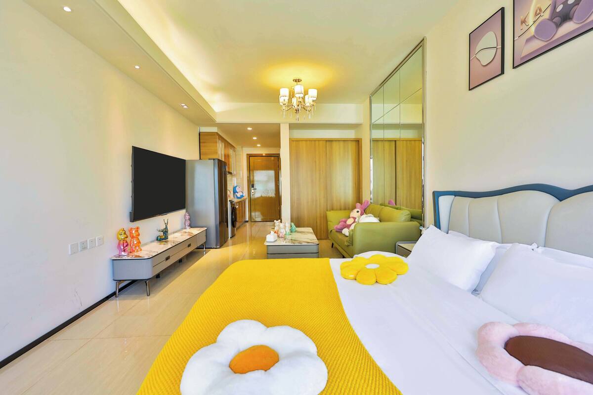 Ein Hotelzimmer mit einem großen Bett, einem Fernseher, einer Couch und einer Essecke.