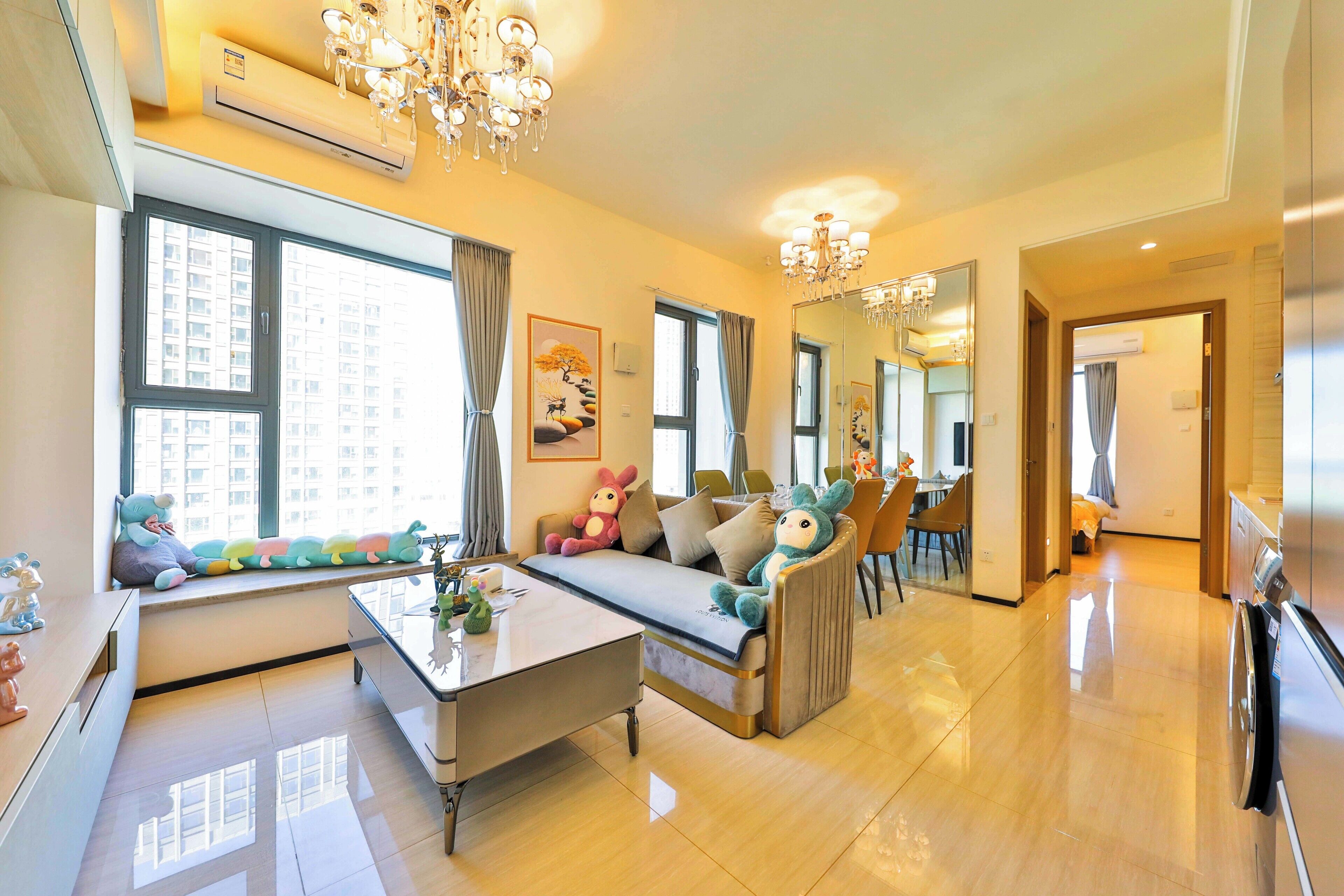 A modern living room with a sofa, a coffee table, and a dining area with chairs.