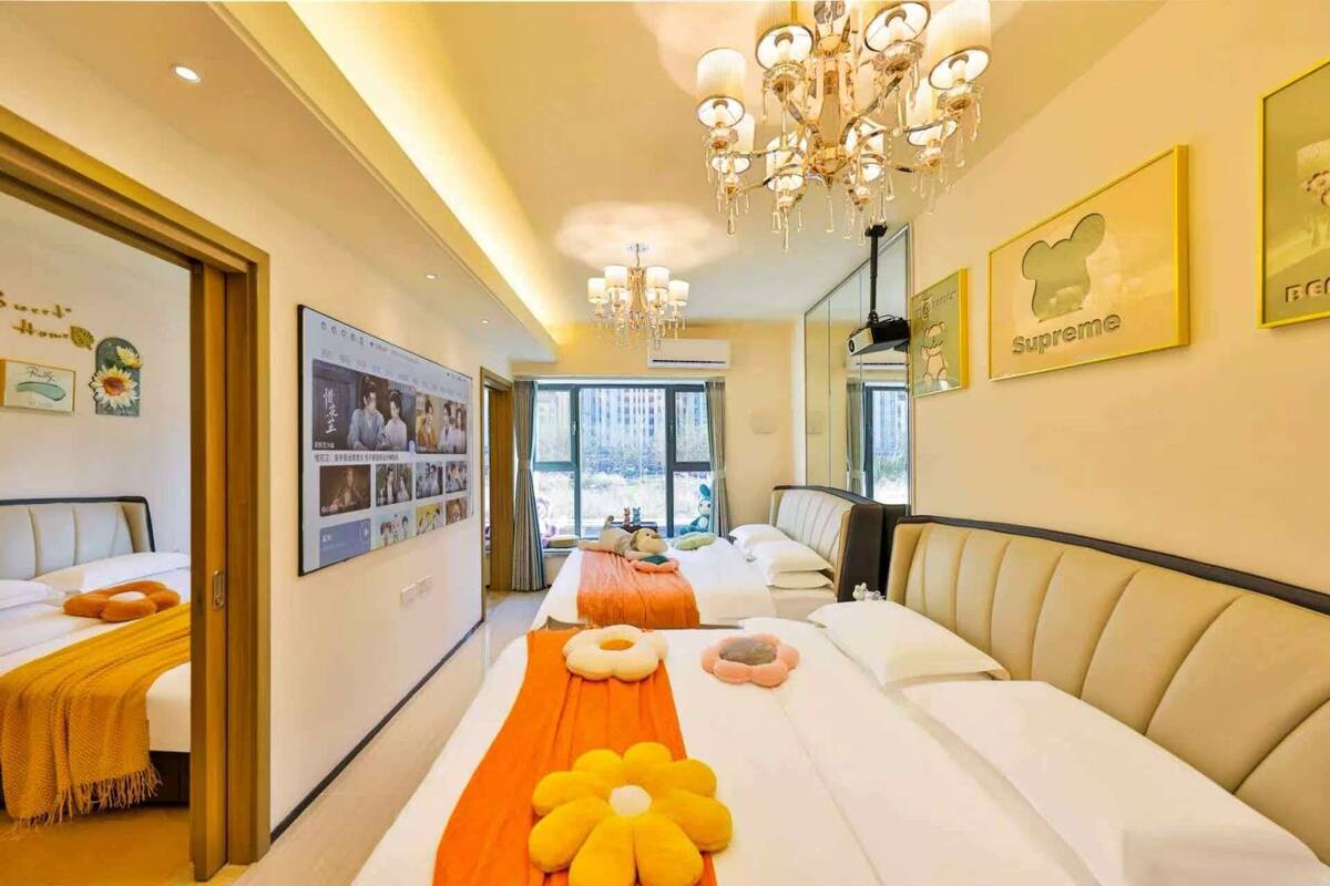 Ein Hotelzimmer mit einem großen Bett, einer Couch, einer Kristallleuchtre und Blick ins Freie.