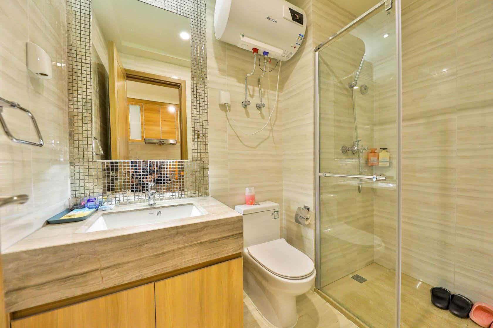 A modern bathroom with a glass shower enclosure, a sink with a mirror, and a toilet.