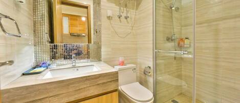 A modern bathroom with a glass shower enclosure, a sink with a mirror, and a toilet.